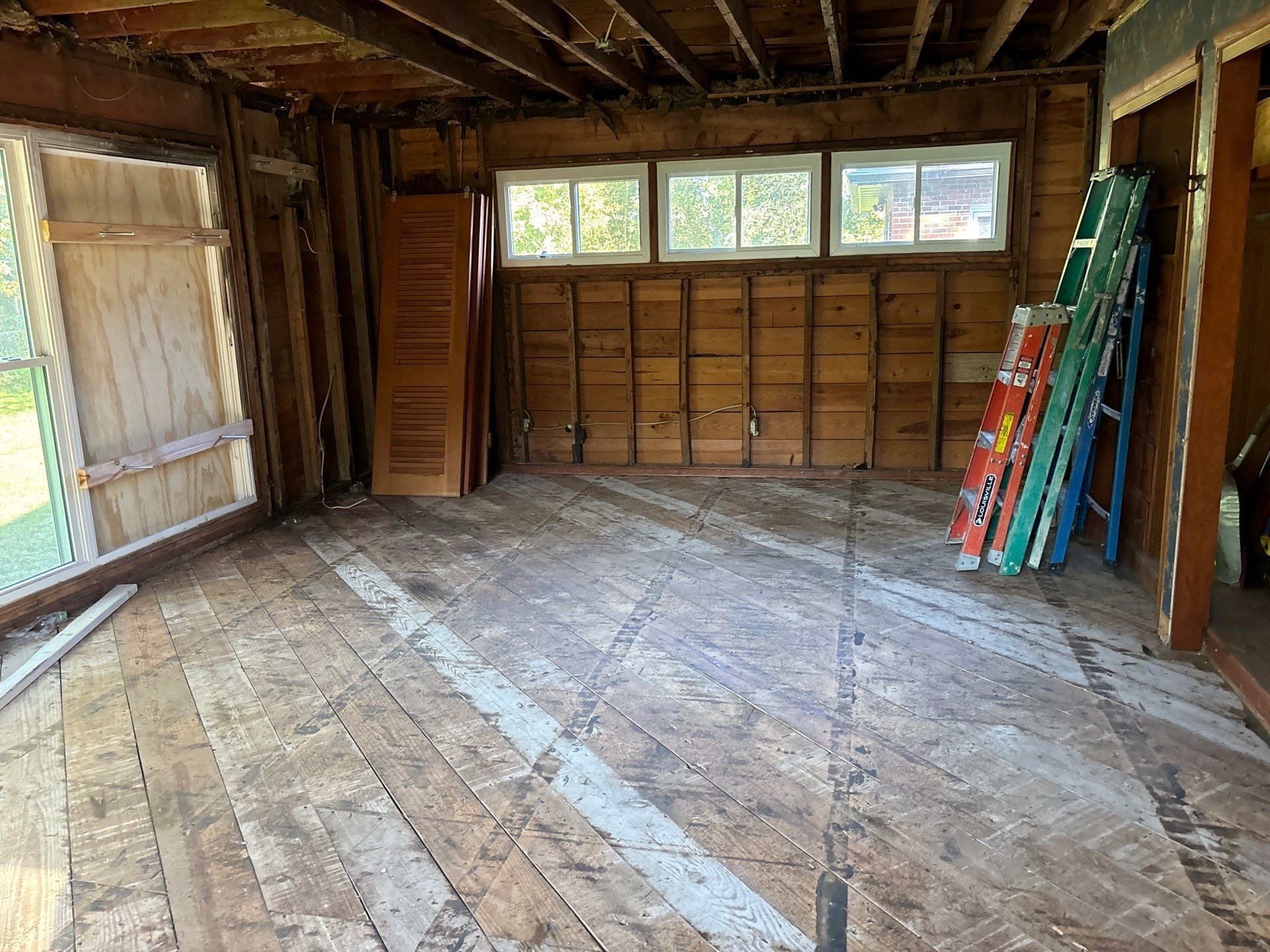 An empty room with a bunch of ladders on the floor