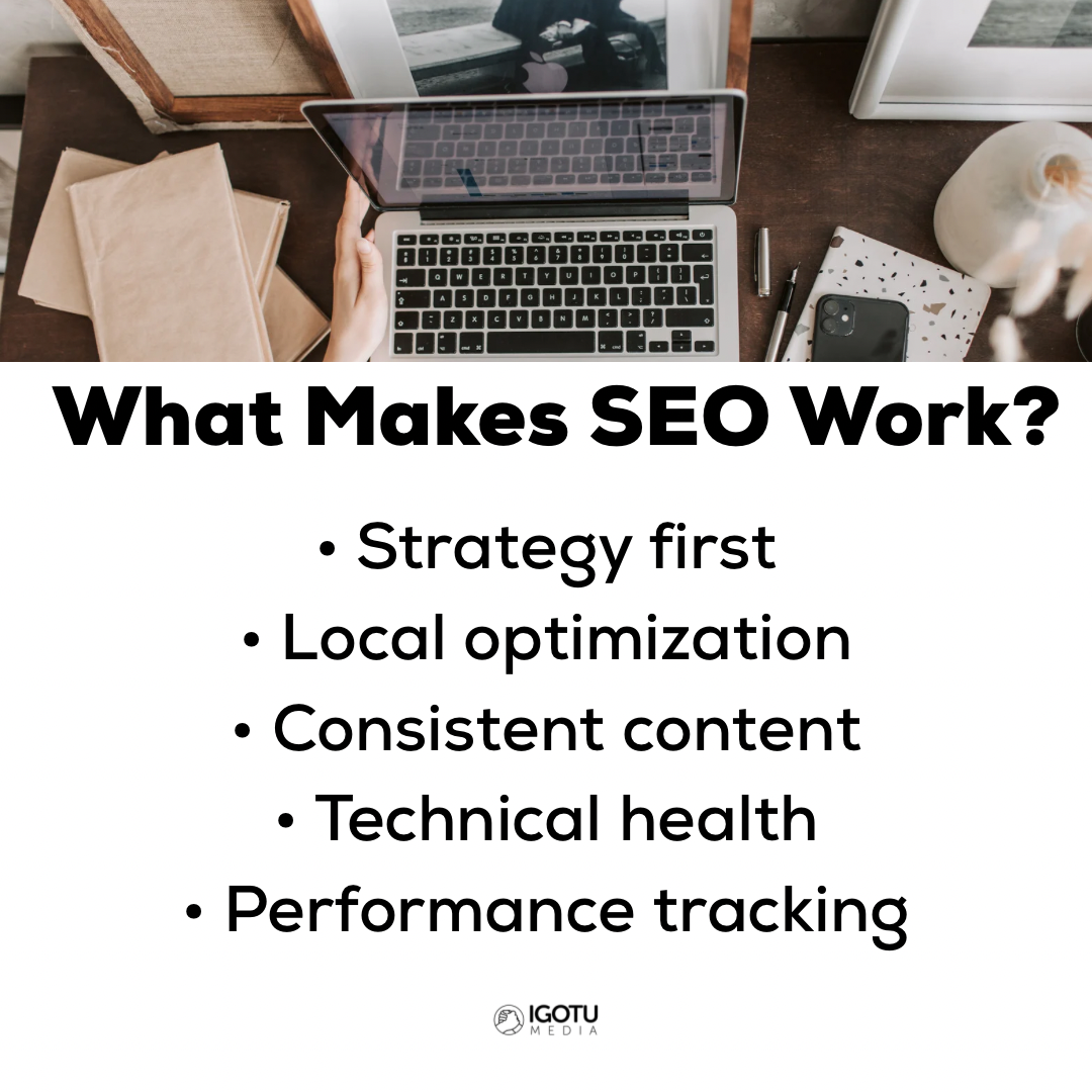 White keyboard on a light wood desk, with a monitor and mug in the background. Natural light from a window.