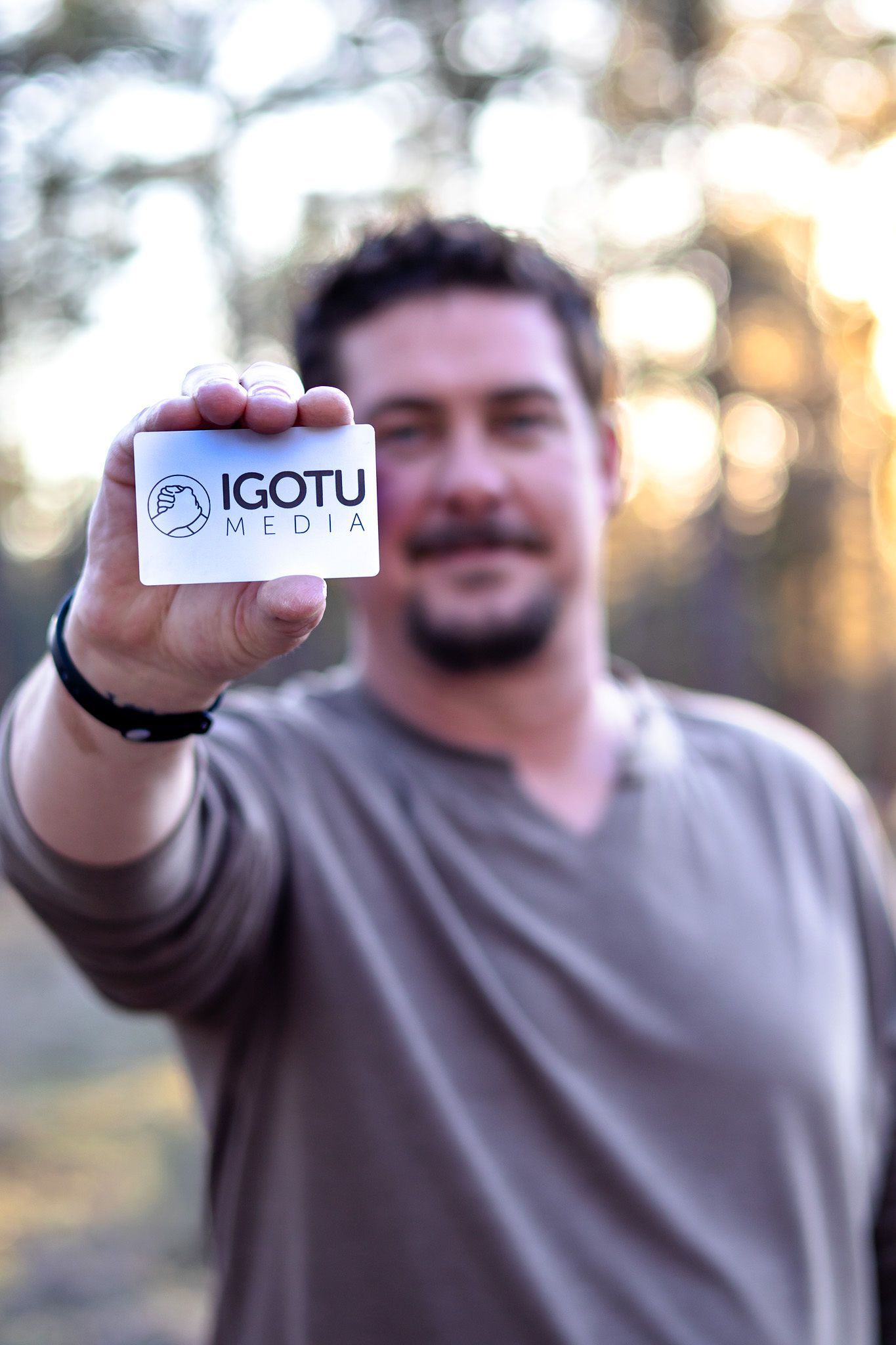 JD Holding a business card with blur background