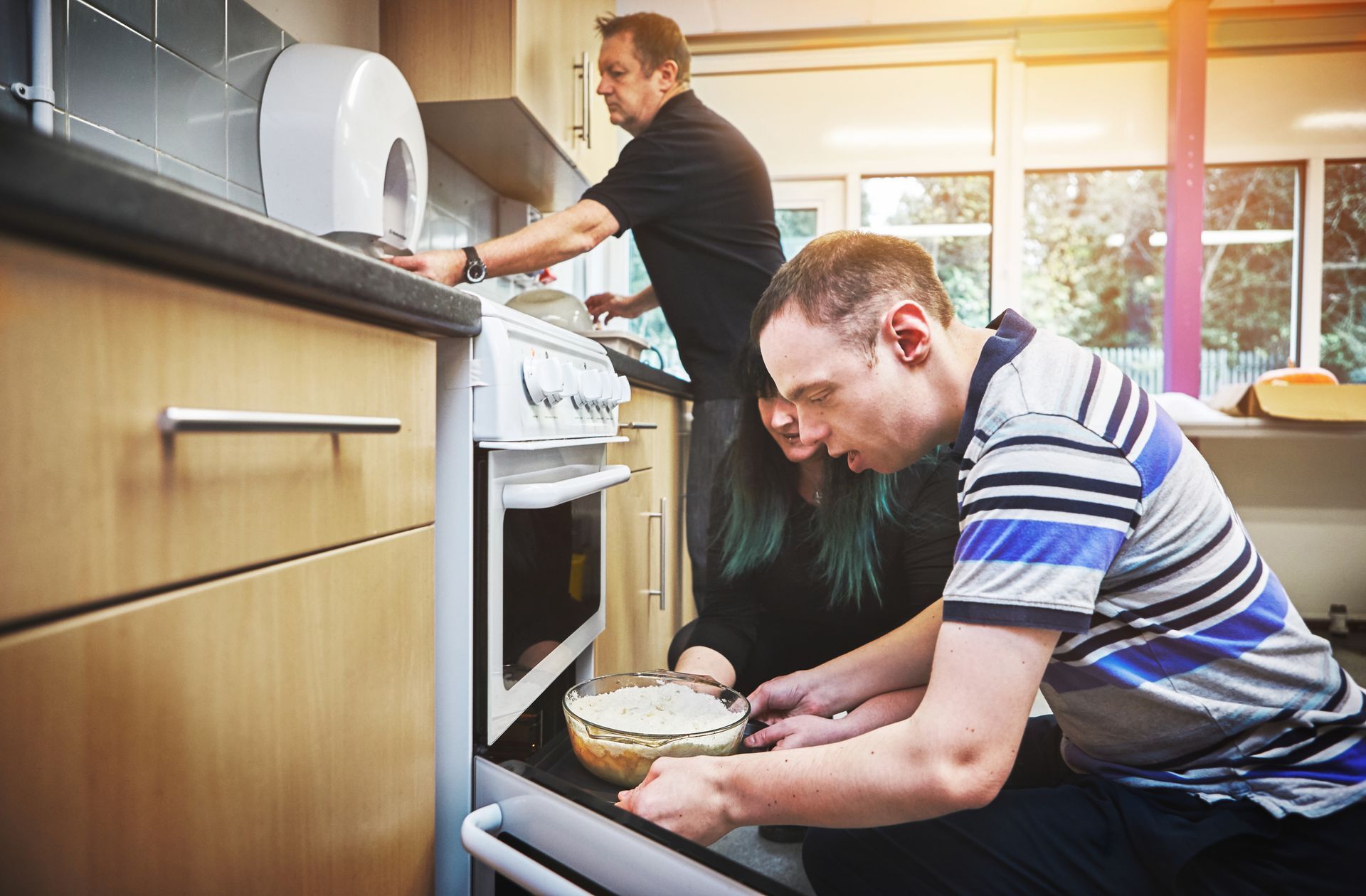 A man with disabilities is learning basic baking skills in a facility for people with special needs.