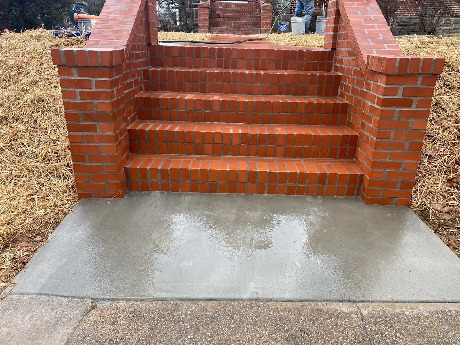 A set of brick stairs leading up to a concrete walkway.