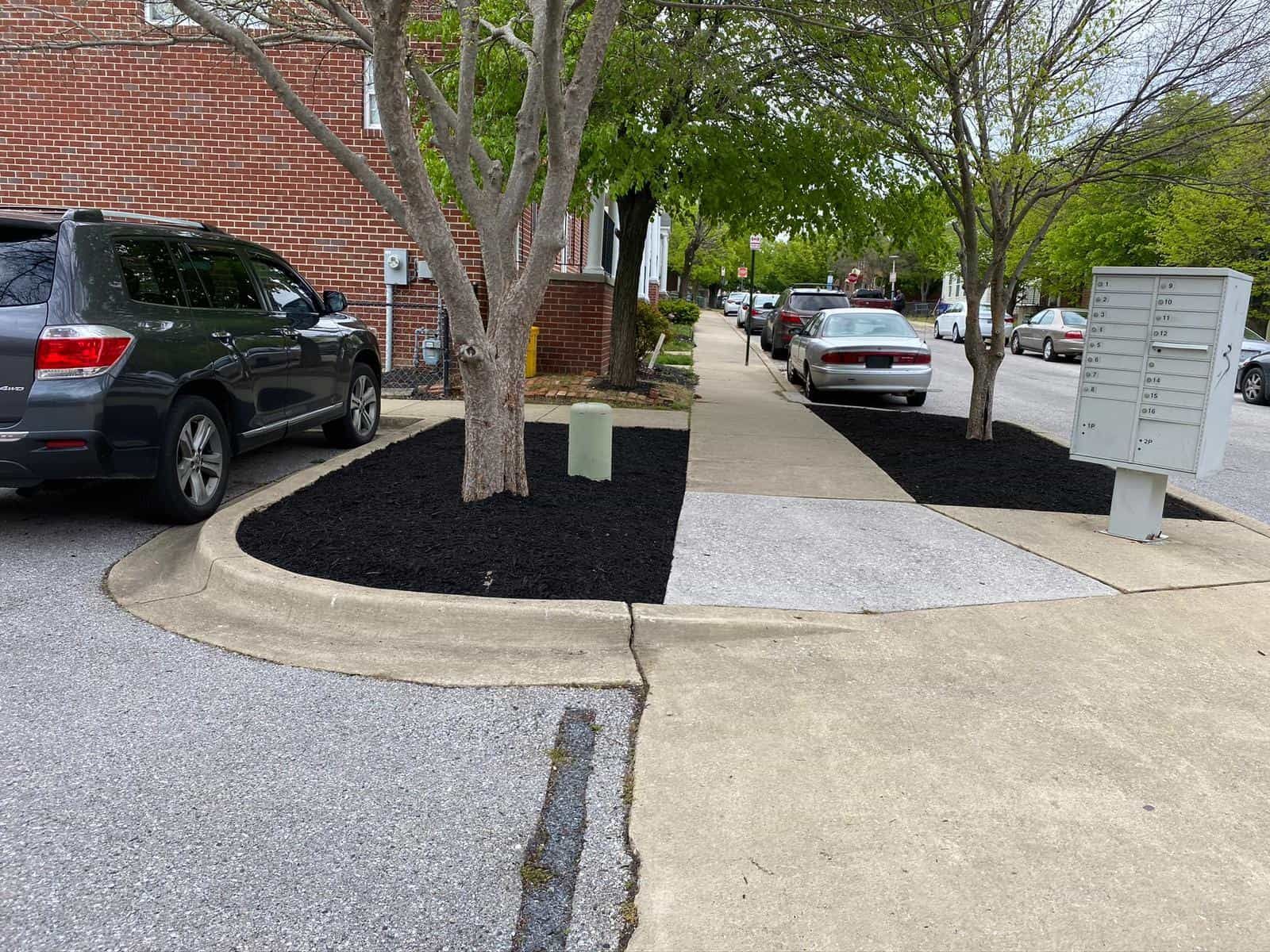 A car is parked on the side of the road next to a mailbox.
