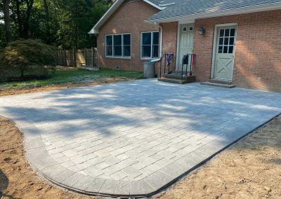 A brick house with a patio in front of it.