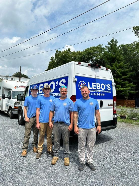 A group of men are standing in front of a white van.