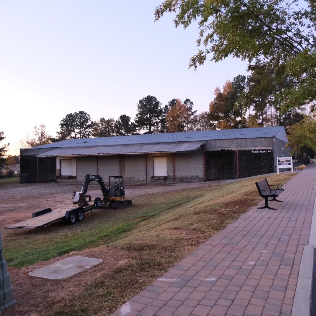 A building with closed doors and a trailer, next to a brick pathway.