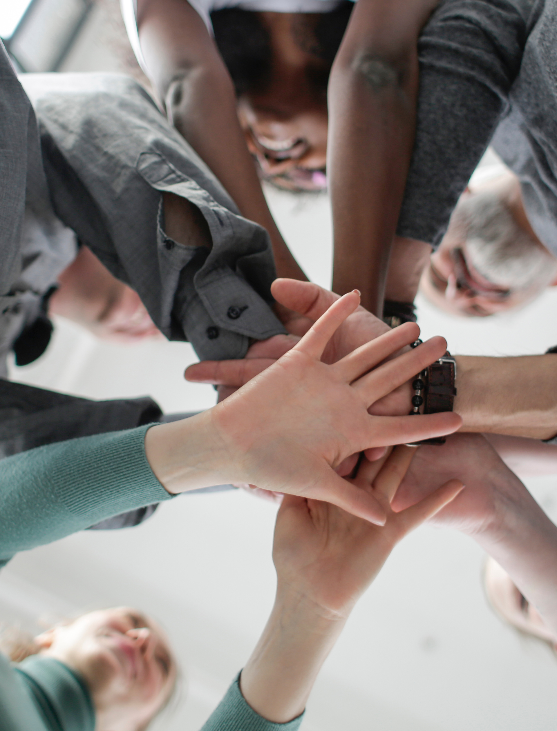 Hands piled together, diverse group celebrating.