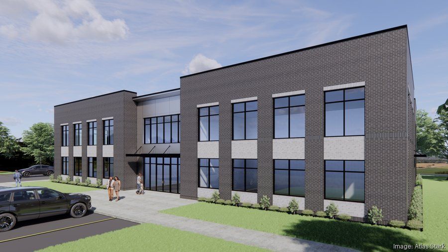 Modern brick office building with glass windows, sidewalk, parked car, and people near the entrance.