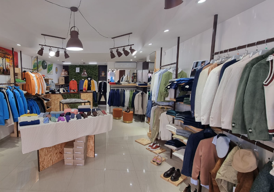 Un negozio di abbigliamento pieno di vestiti e scarpe.