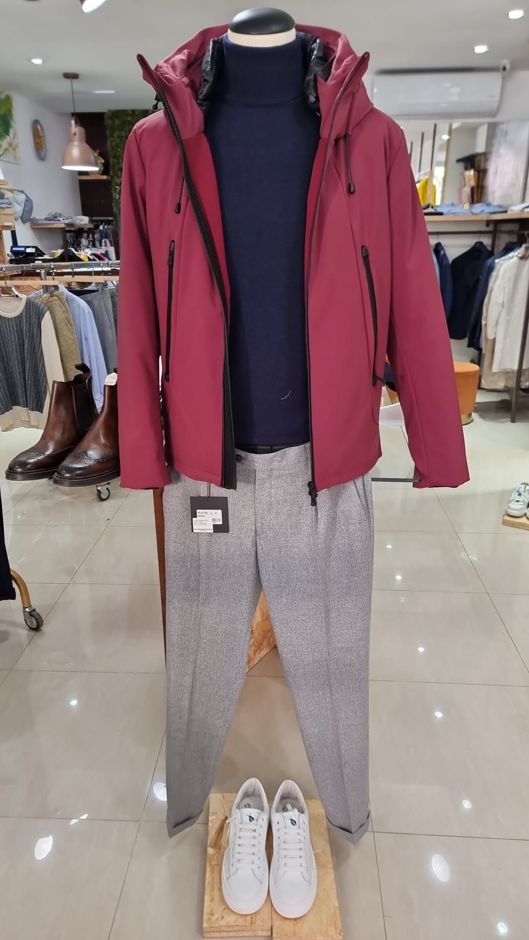 Un manichino indossa una giacca rossa e pantaloni grigi.
