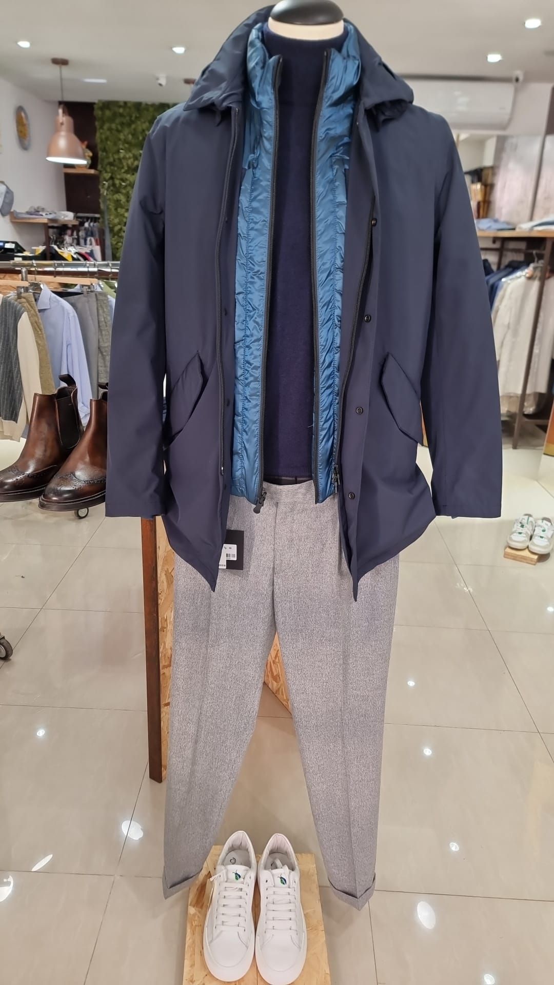 Un uomo indossa giacca e pantaloni in un negozio.