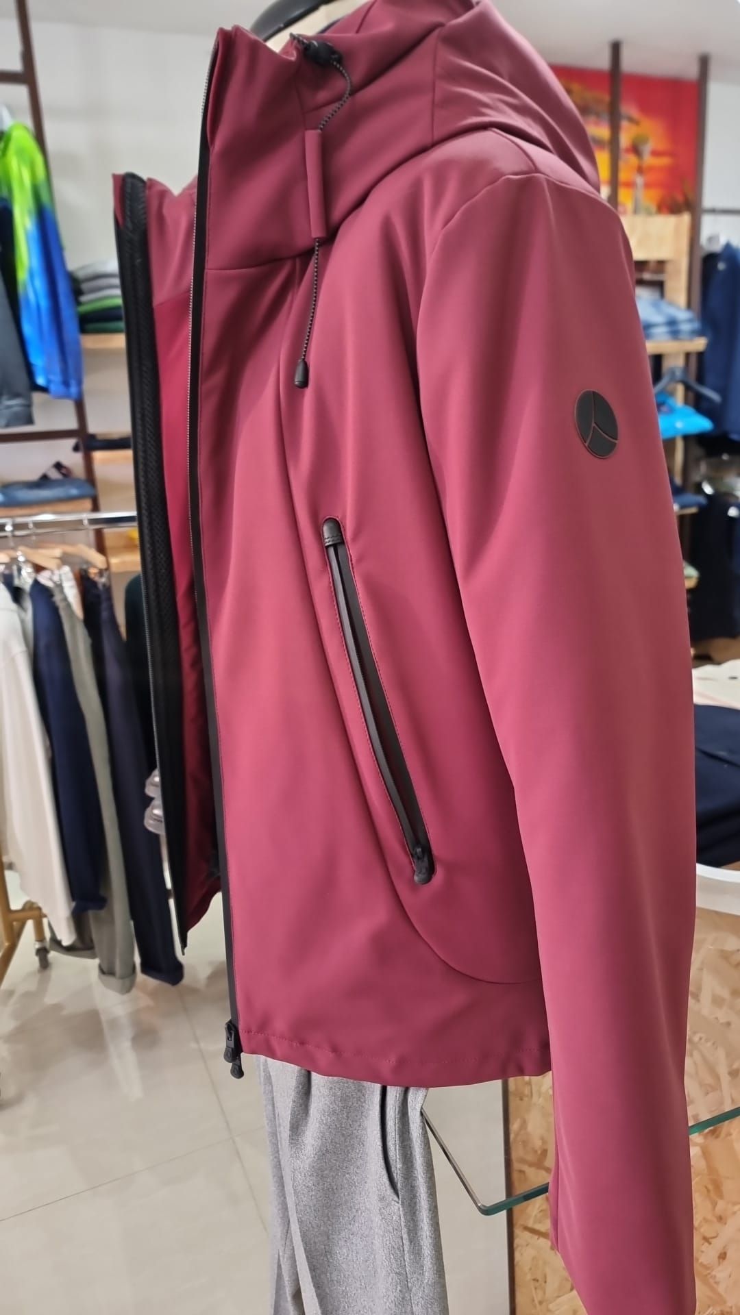 Una giacca rossa con cappuccio è su un manichino in un negozio.