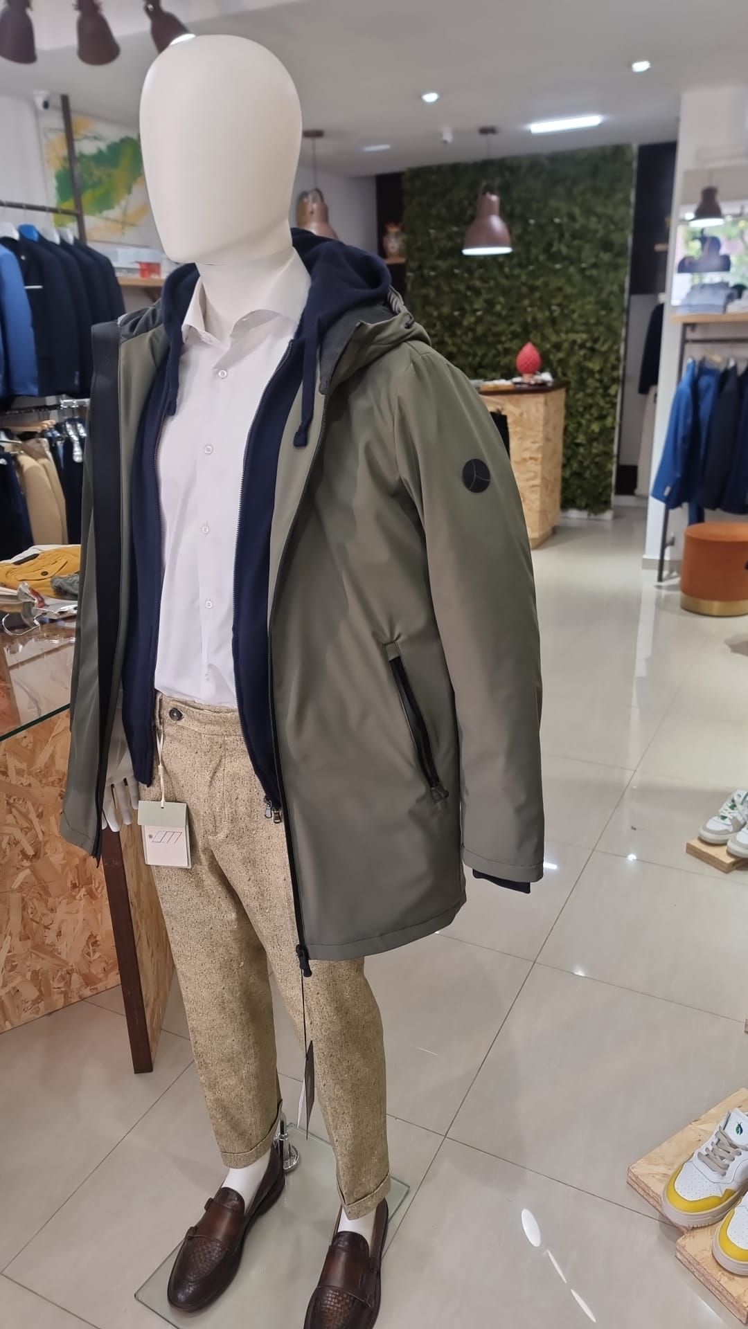 Un manichino indossa una giacca e dei pantaloni in un negozio.