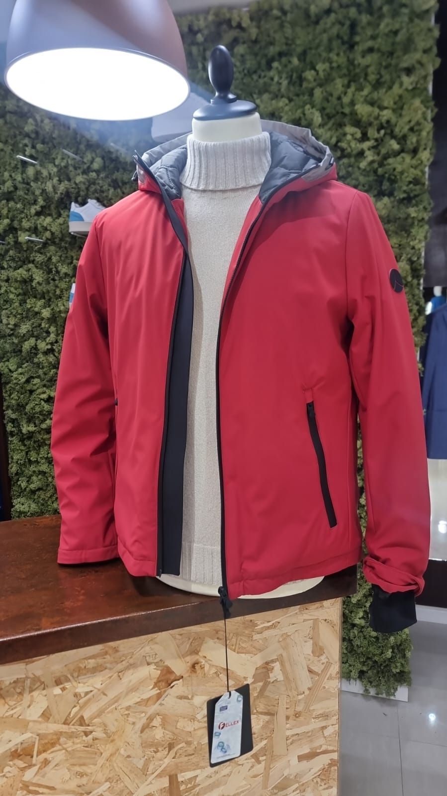 Una giacca rossa con cappuccio è su un manichino.