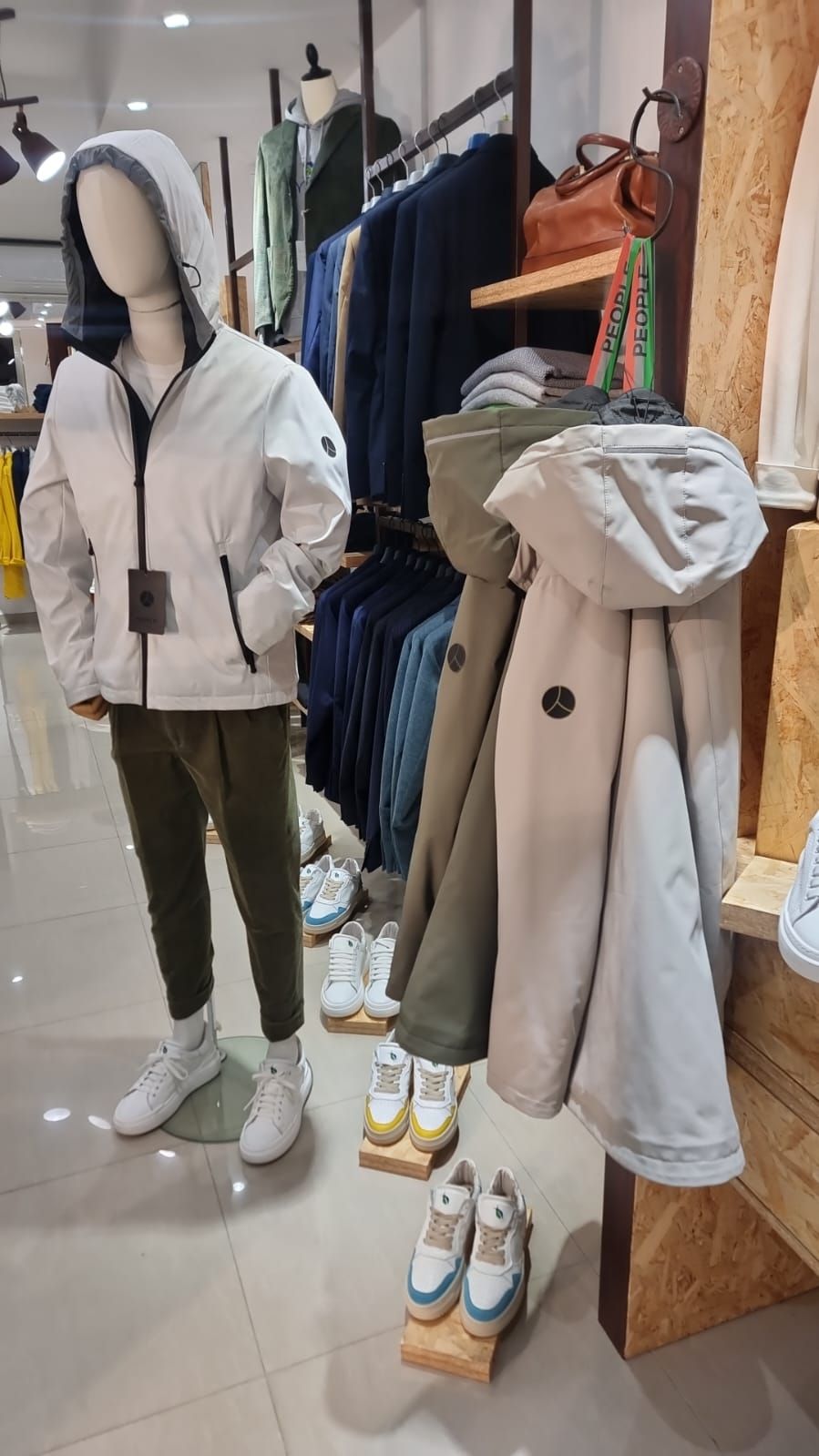 Un manichino indossa una giacca bianca e pantaloni in un negozio di abbigliamento.