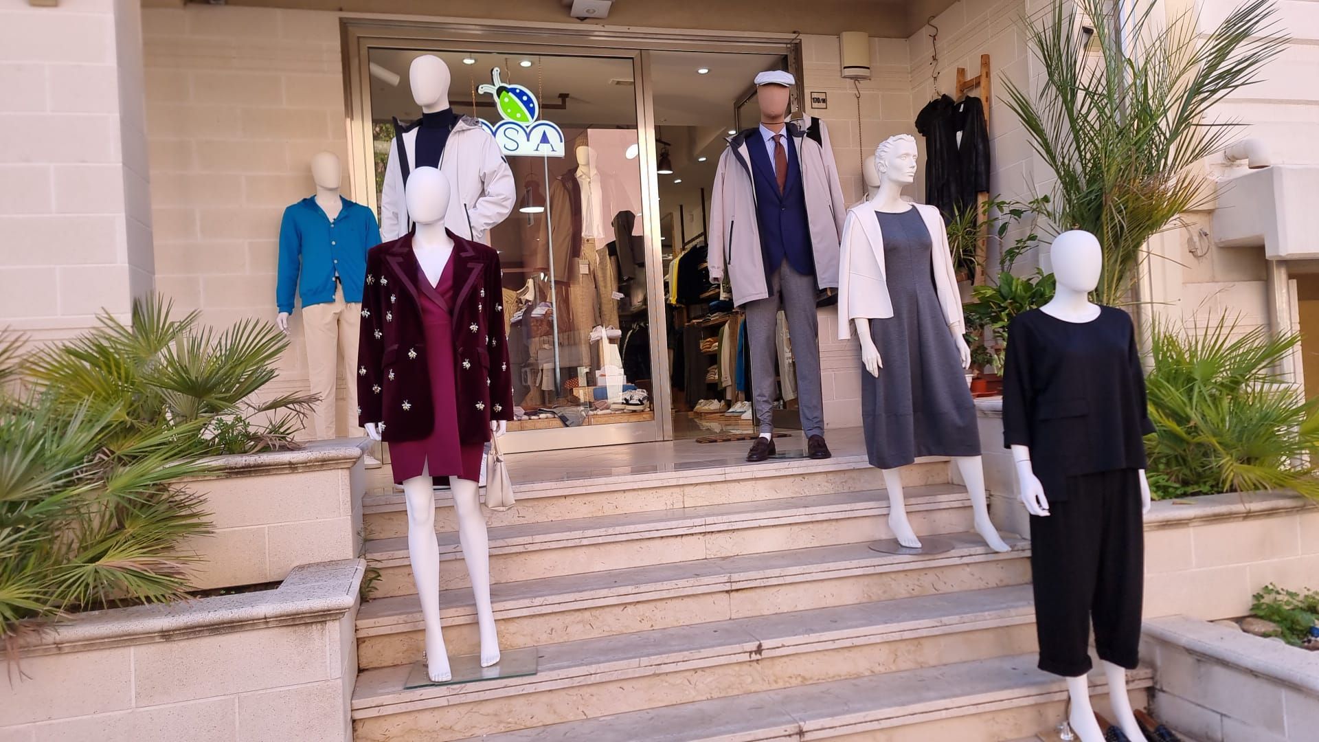 Un gruppo di manichini è in piedi davanti a un negozio.