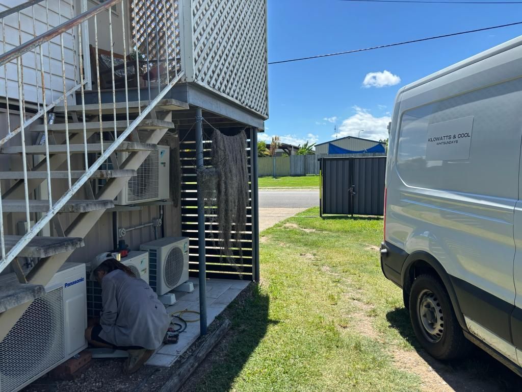 Someone is Working on an Air Conditioner Outside of a Building — Kilowatts & Cool Whitsundays In Strathdickie, QLD