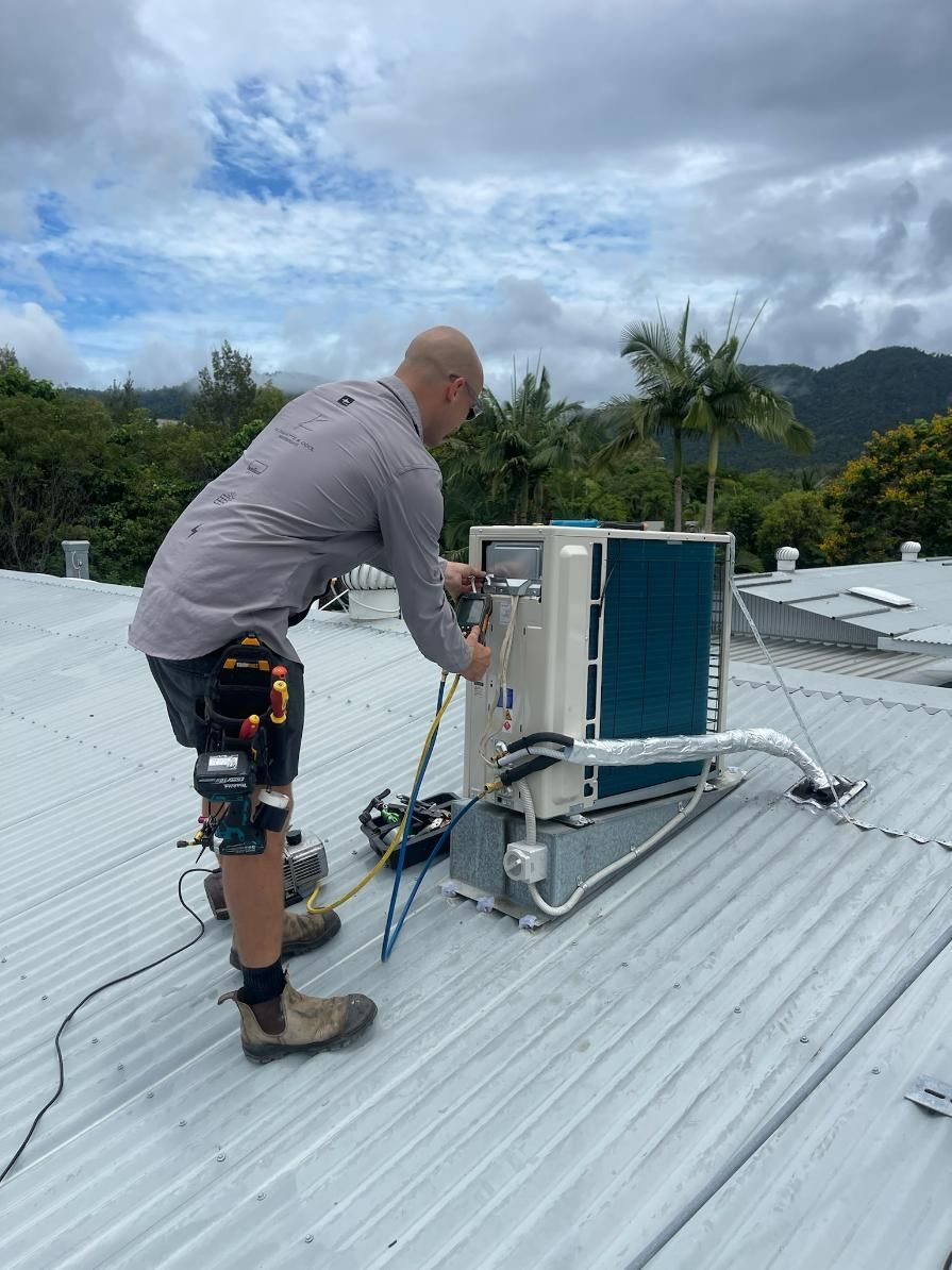 A Man Is Working on An Air Conditioner on A Roof — Kilowatts & Cool Whitsundays In Cannonvale, QLD