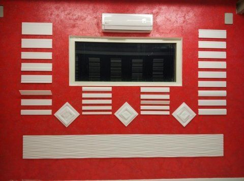 Parete rossa con decorazioni in stucco bianche