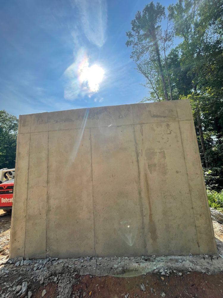 A large concrete wall is being built on a sunny day.