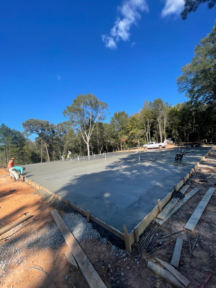 A concrete slab is being built on top of a dirt hill.