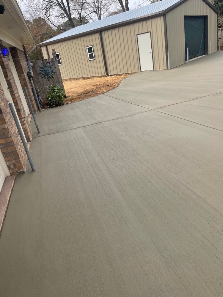 A concrete driveway with a garage in the background.