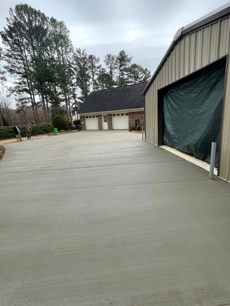 A concrete driveway is being built in front of a garage.