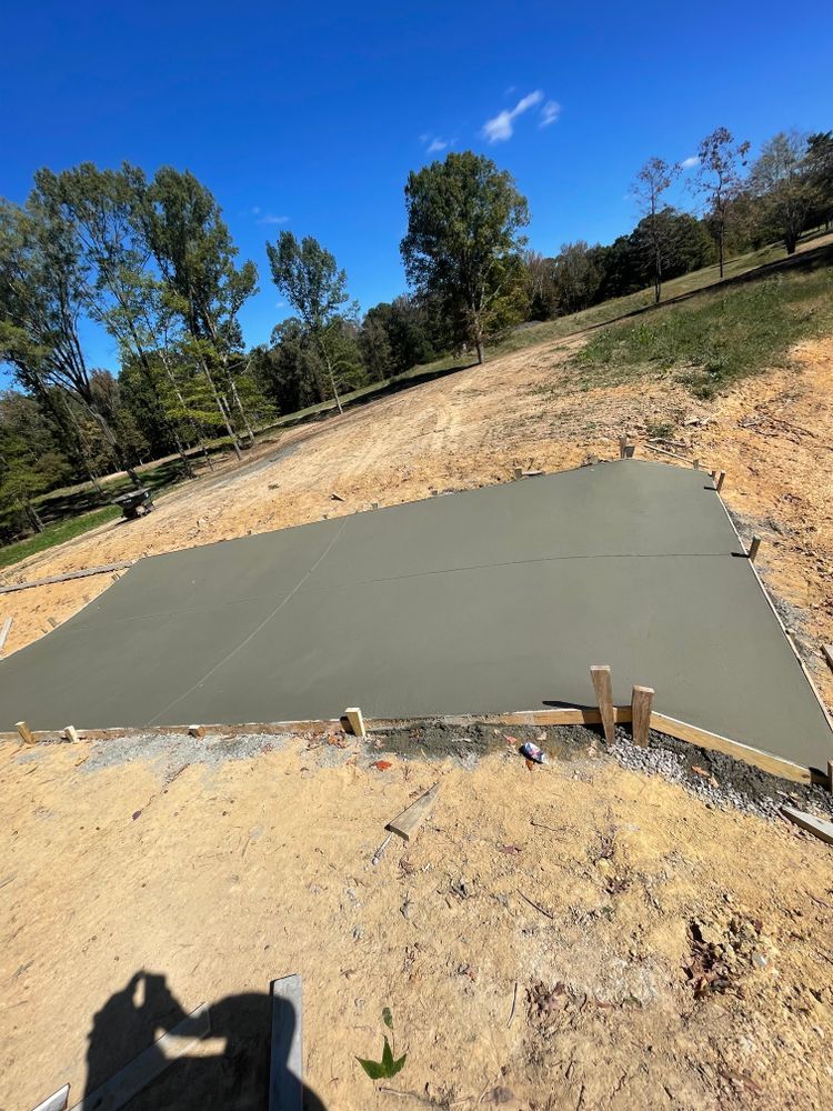 A large concrete slab is sitting on top of a dirt field.