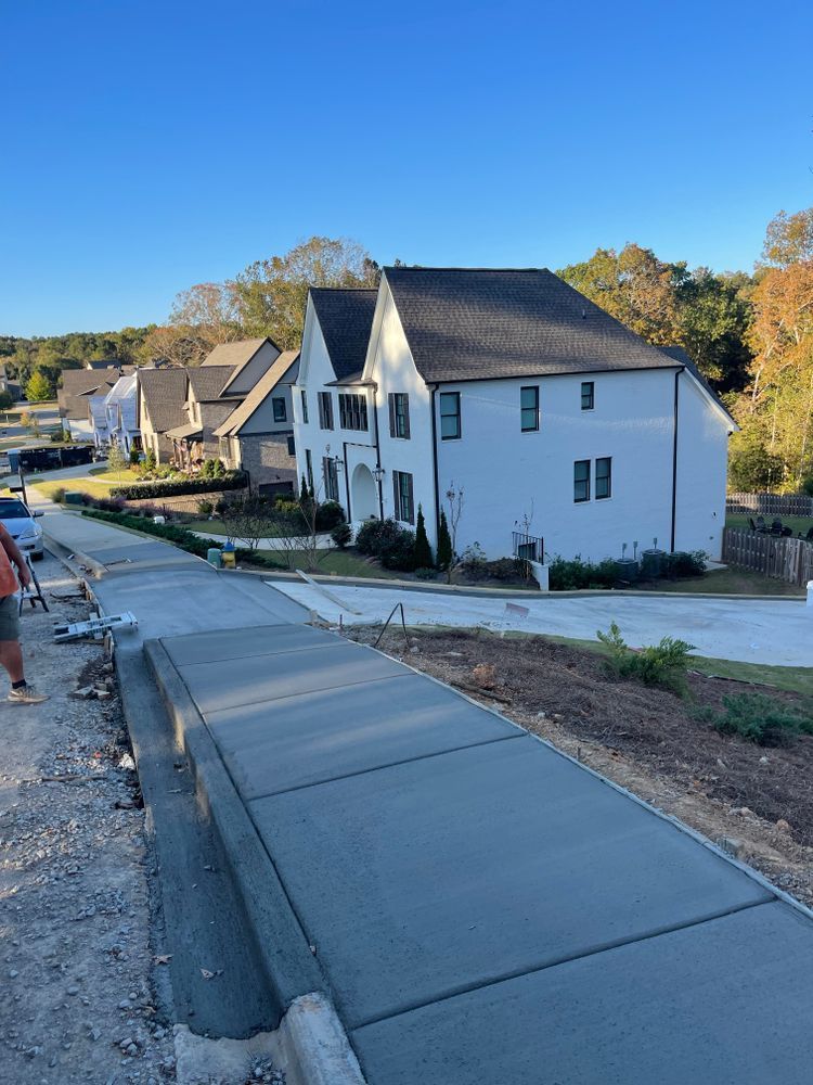 A concrete sidewalk is being built in front of a white house.