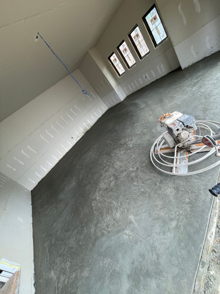 A person is working on a concrete floor in a room.