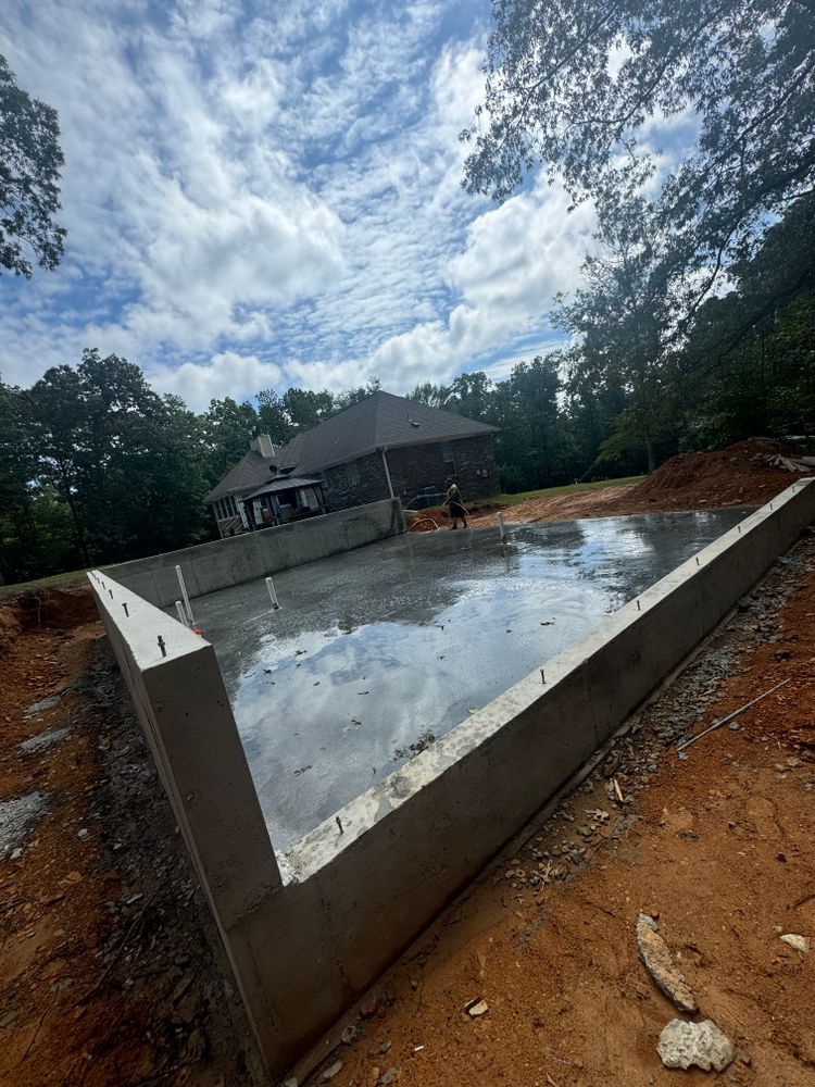 A concrete foundation is being built in front of a house.