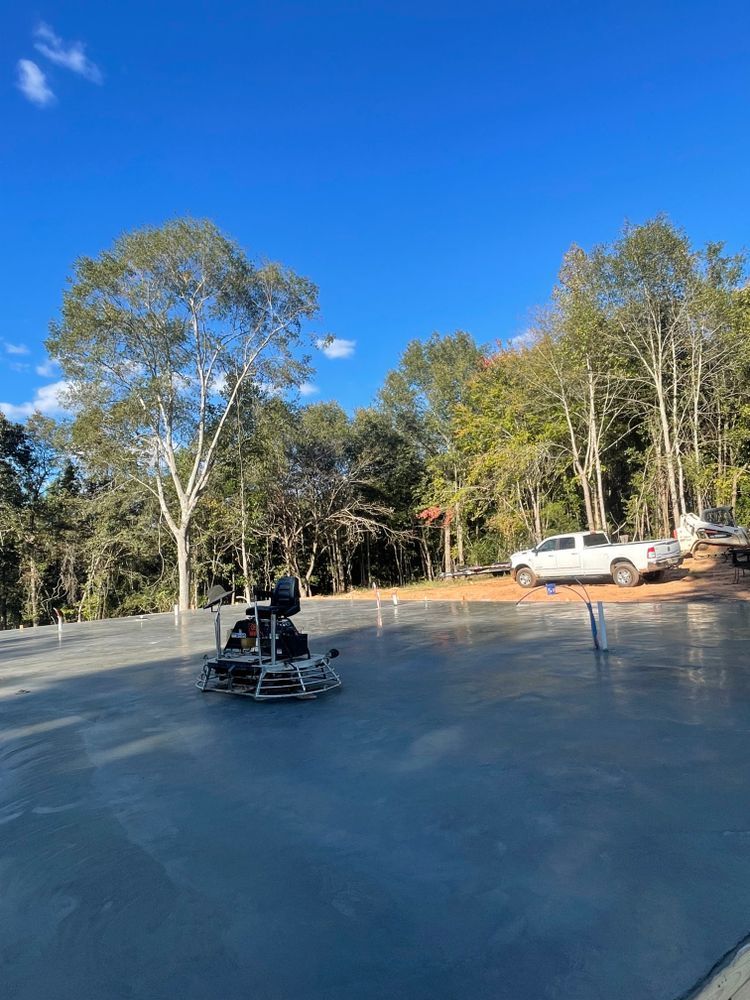 A person is riding a motorcycle on a concrete surface in a parking lot.