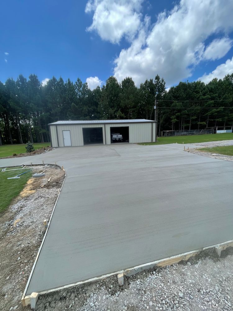 A concrete driveway is being built in front of a garage.