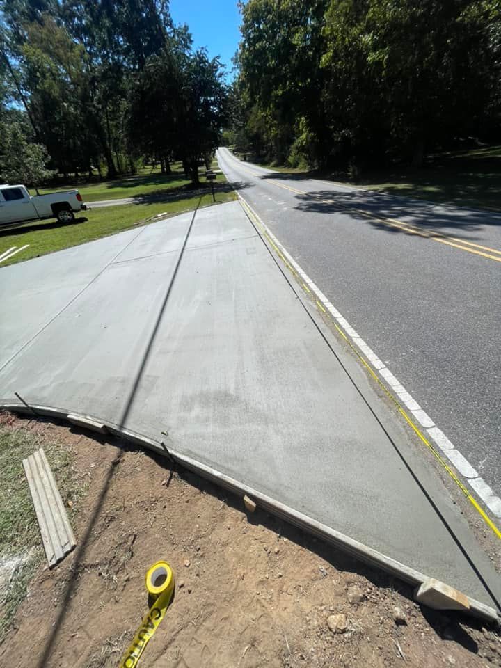 A concrete sidewalk is being built on the side of a road.