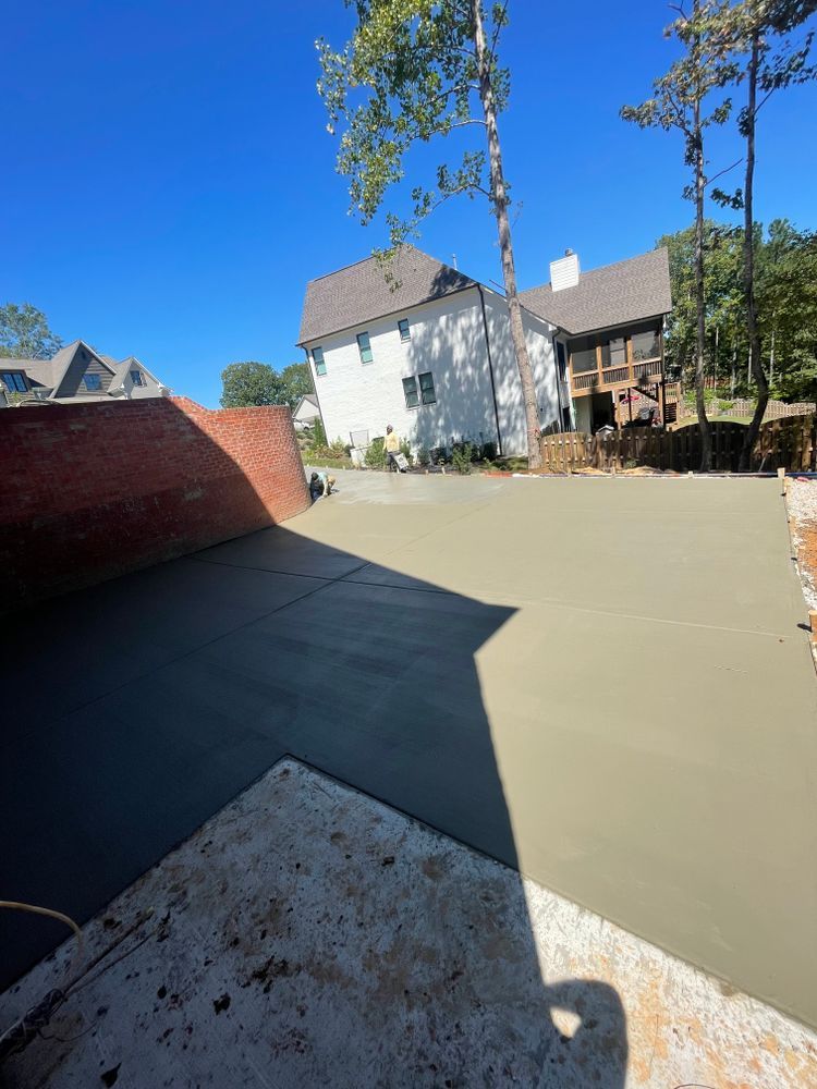 A concrete driveway is being built in front of a large house.
