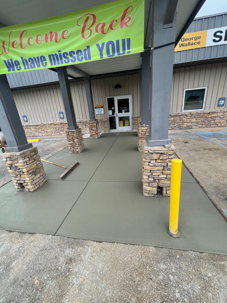 A concrete walkway leading to a building with a sign that says welcome back we have missed you.