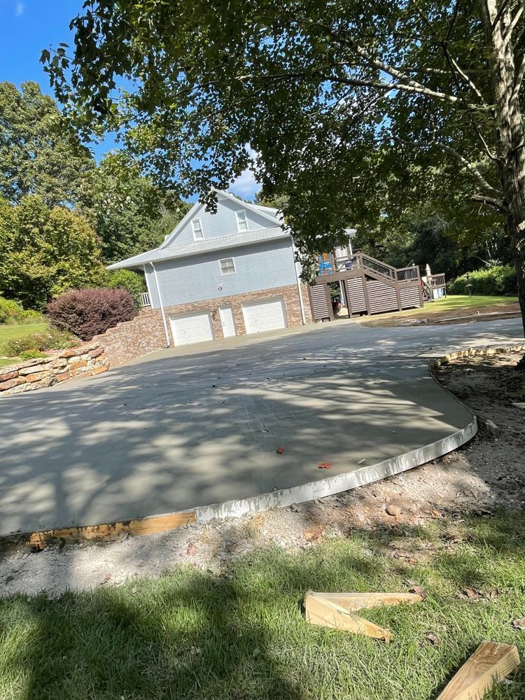 A concrete driveway is being built in front of a house.