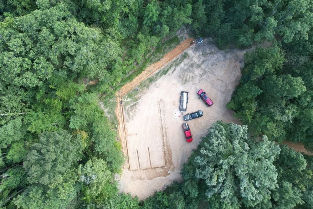 An aerial view of a dirt road in the middle of a forest.