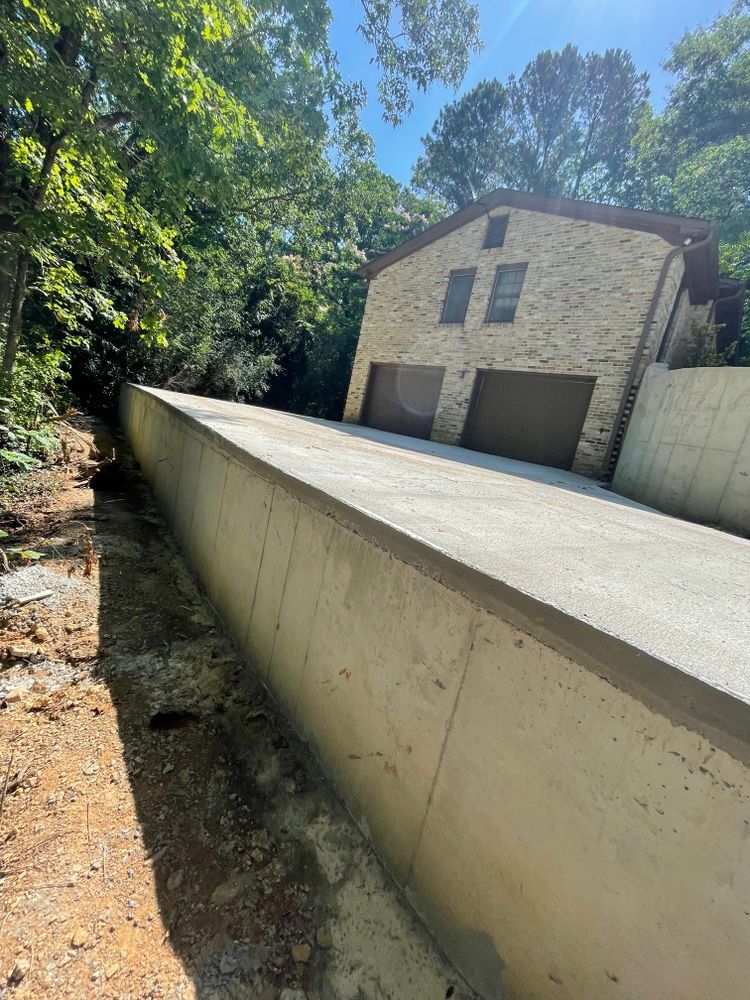 A concrete wall is being built in front of a house.