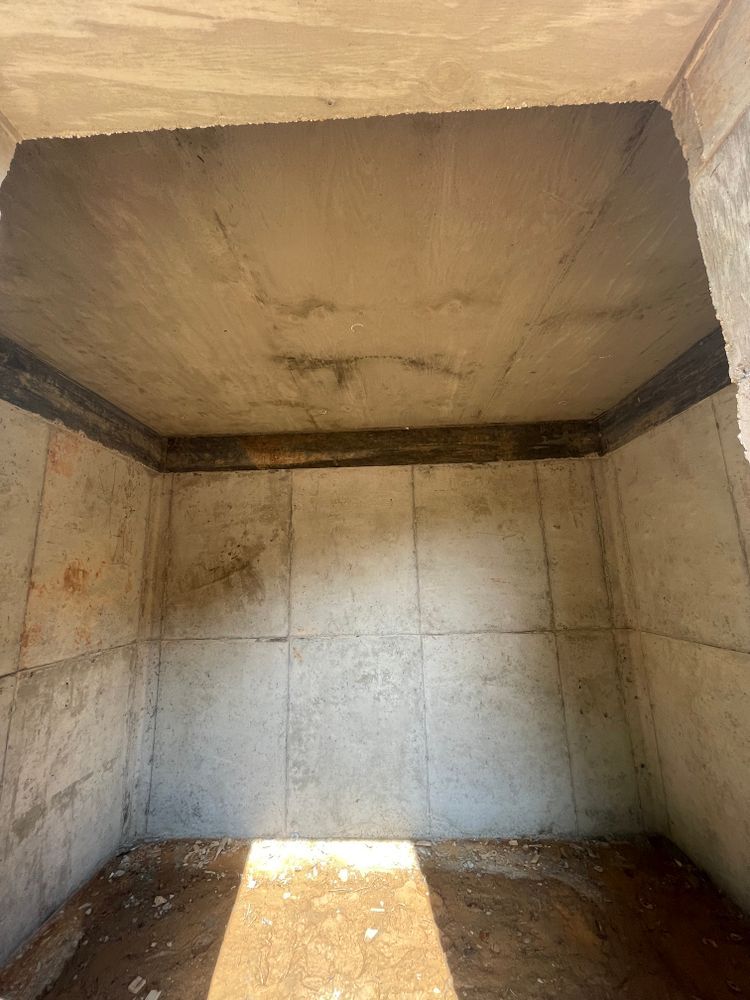 An empty room with concrete walls and a ceiling.