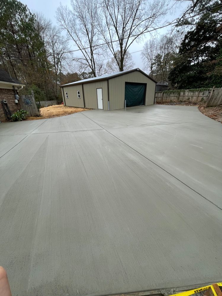 A concrete driveway with a garage in the background.
