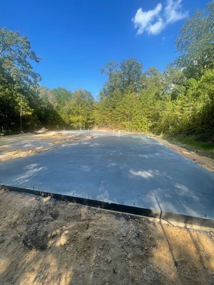 A concrete driveway is being built in the middle of a forest.