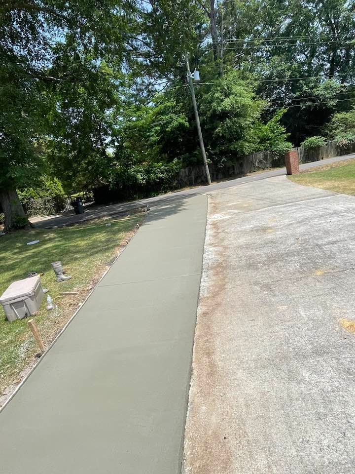 A concrete walkway is being built in the middle of a driveway.