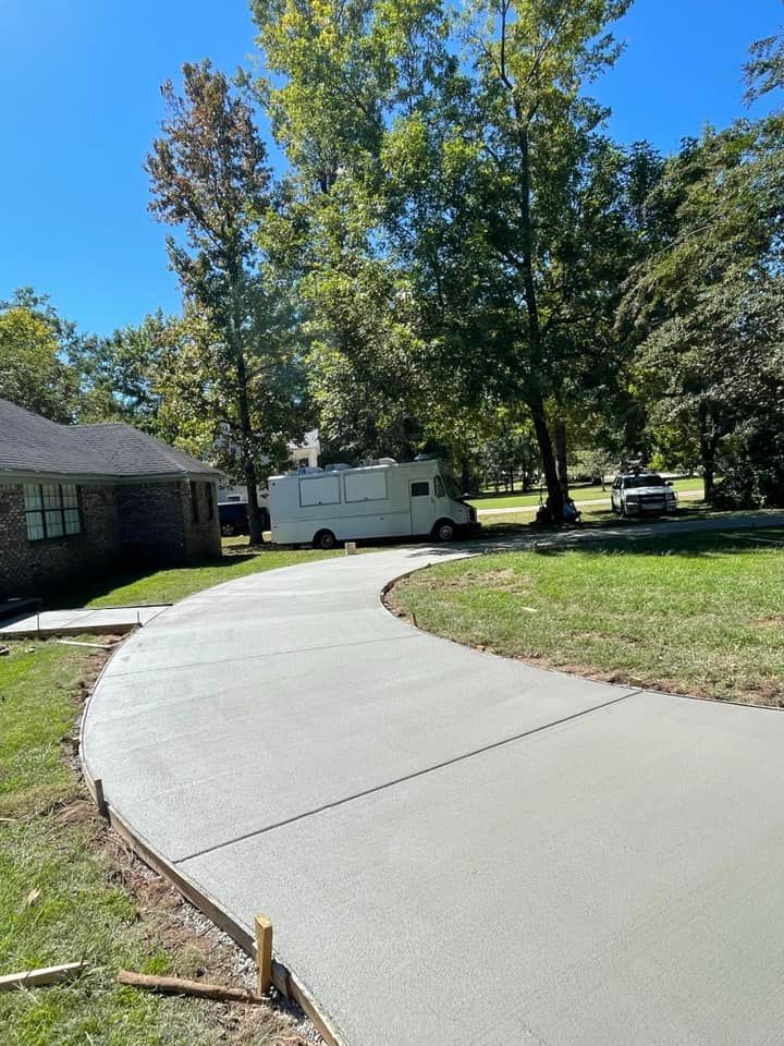 A concrete driveway is being built in front of a house.
