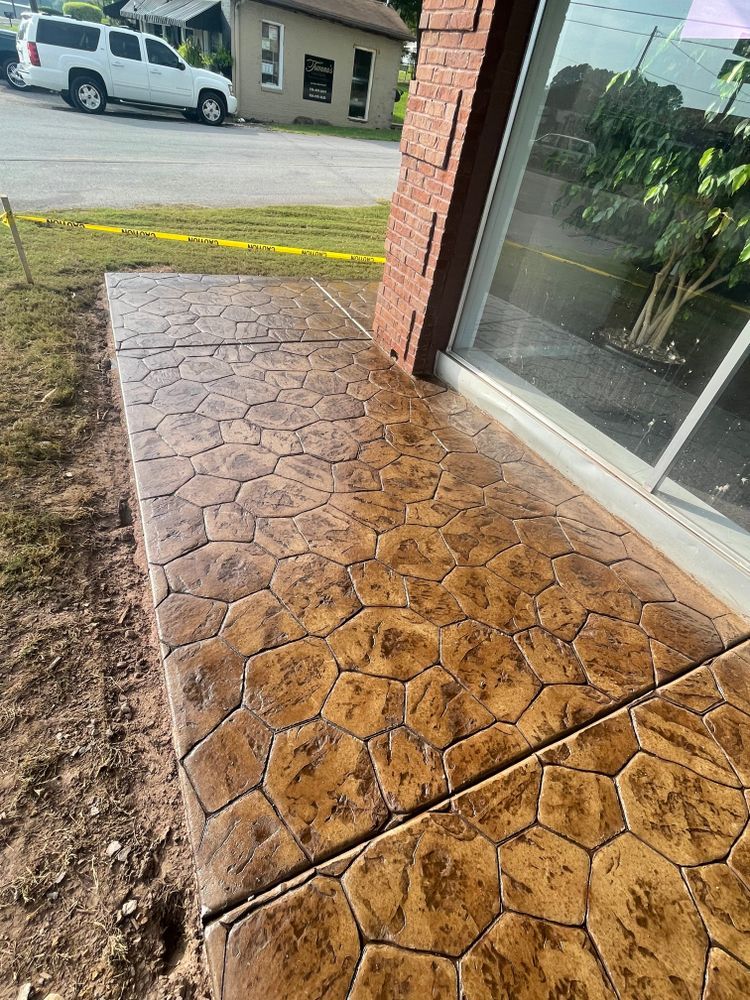 A concrete walkway is being built in front of a brick building.