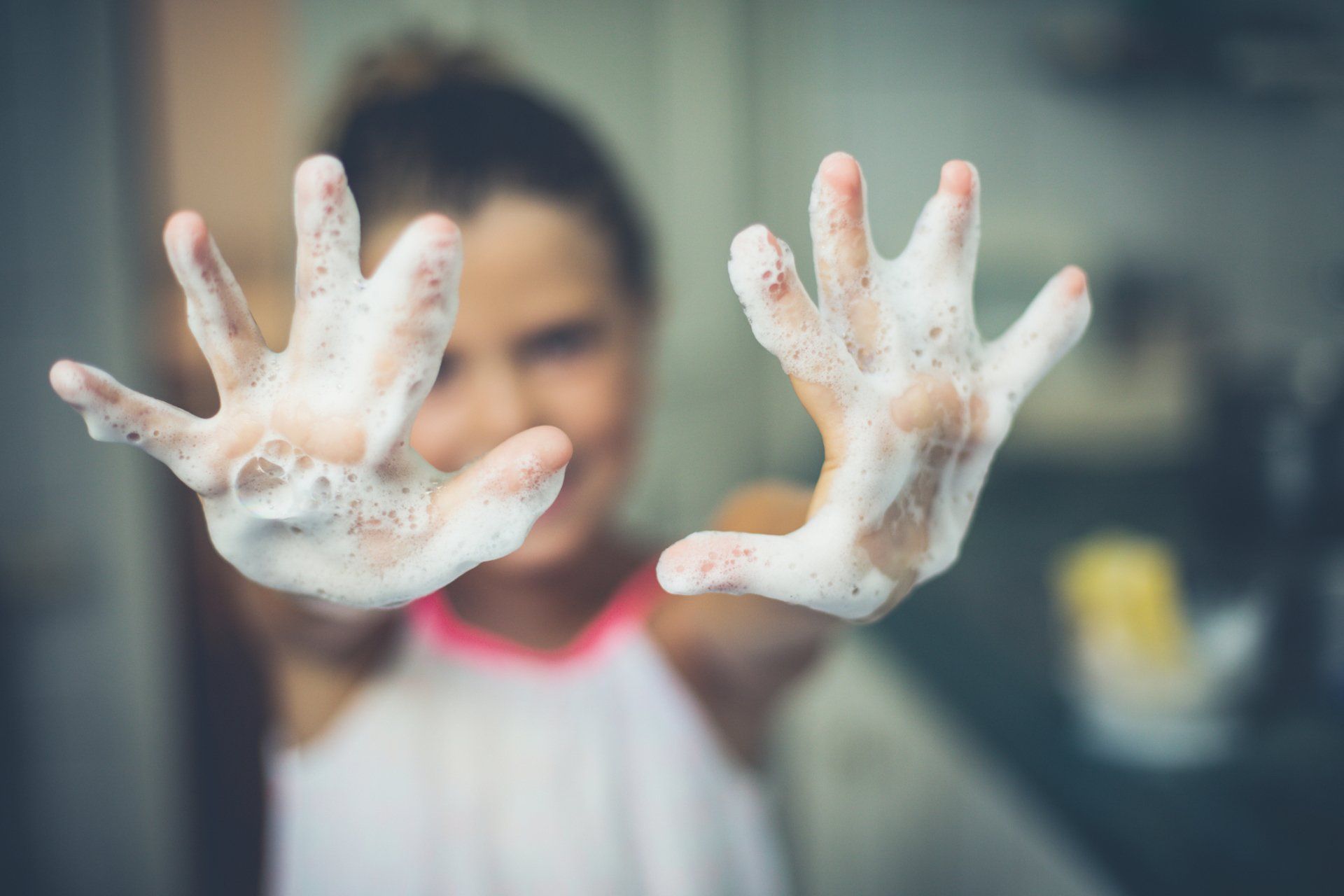 child with soap covered hands