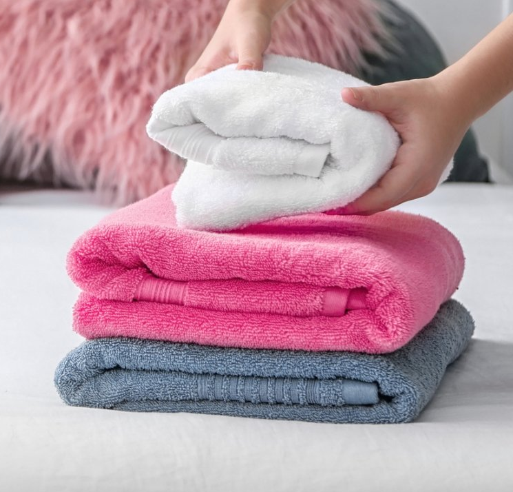 persons hands folding towels