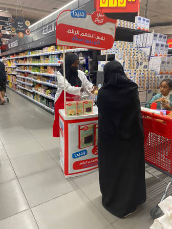 A woman in a black dress is standing at a table in a store