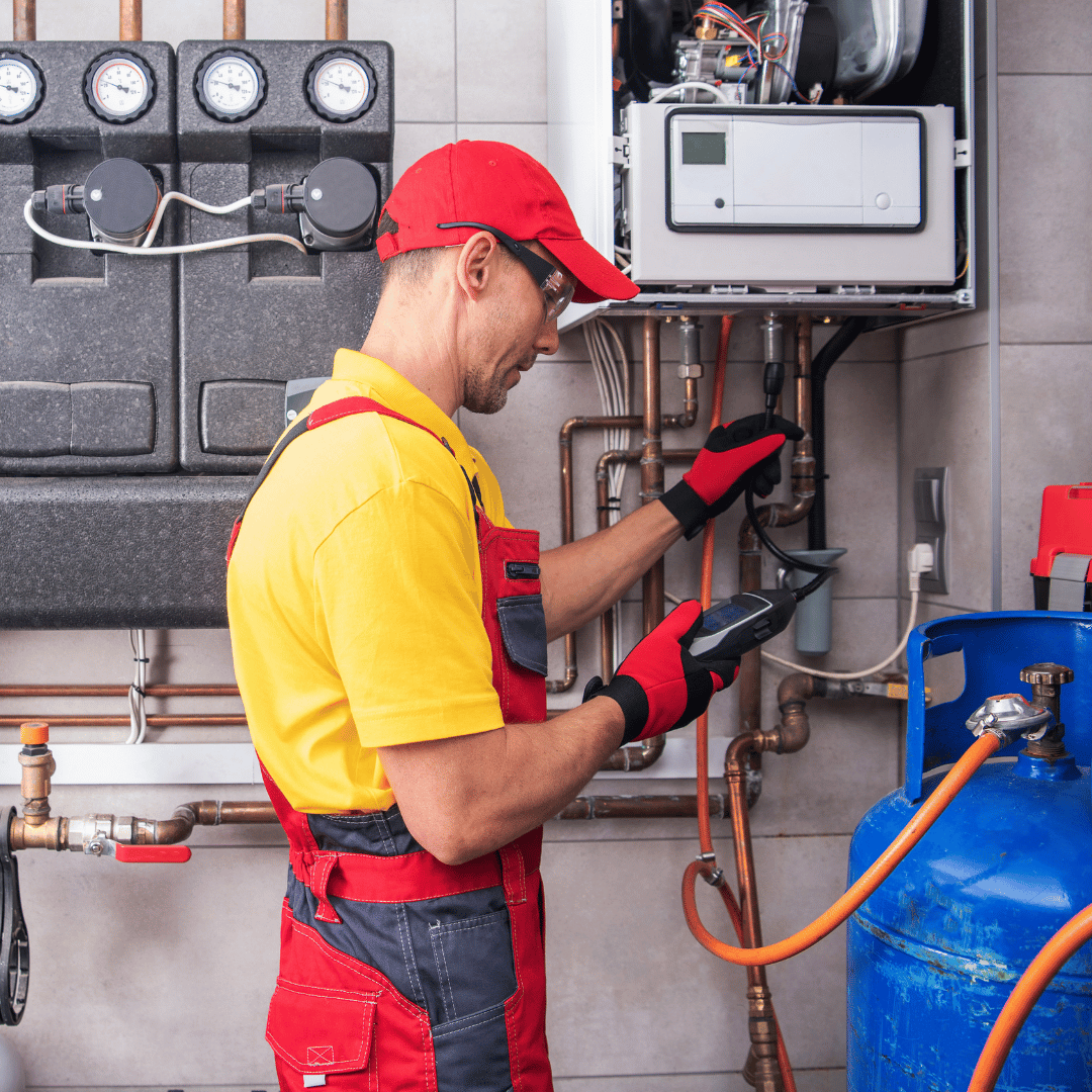 A man is working on a gas heater in a room.