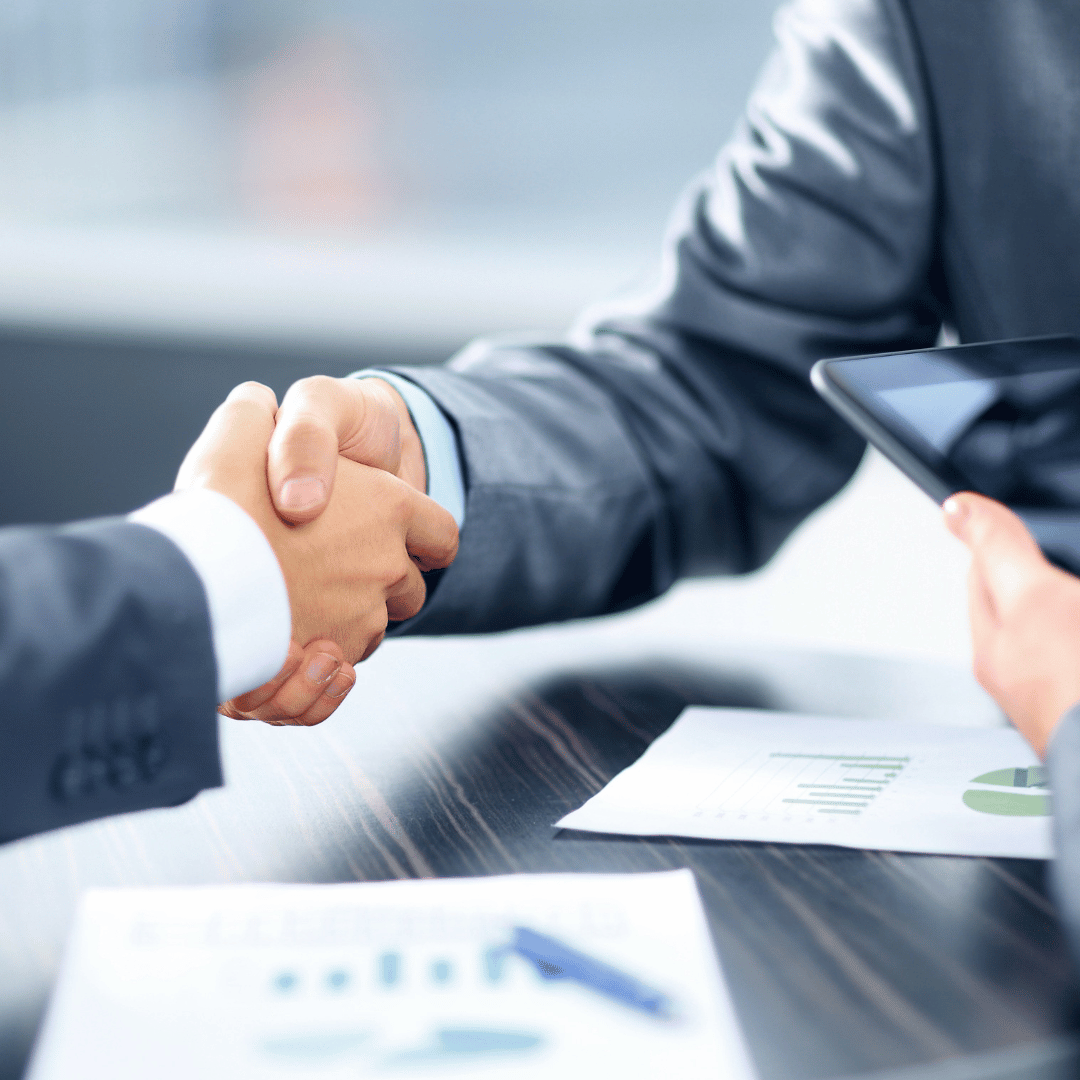 A man in a suit is shaking hands with another man