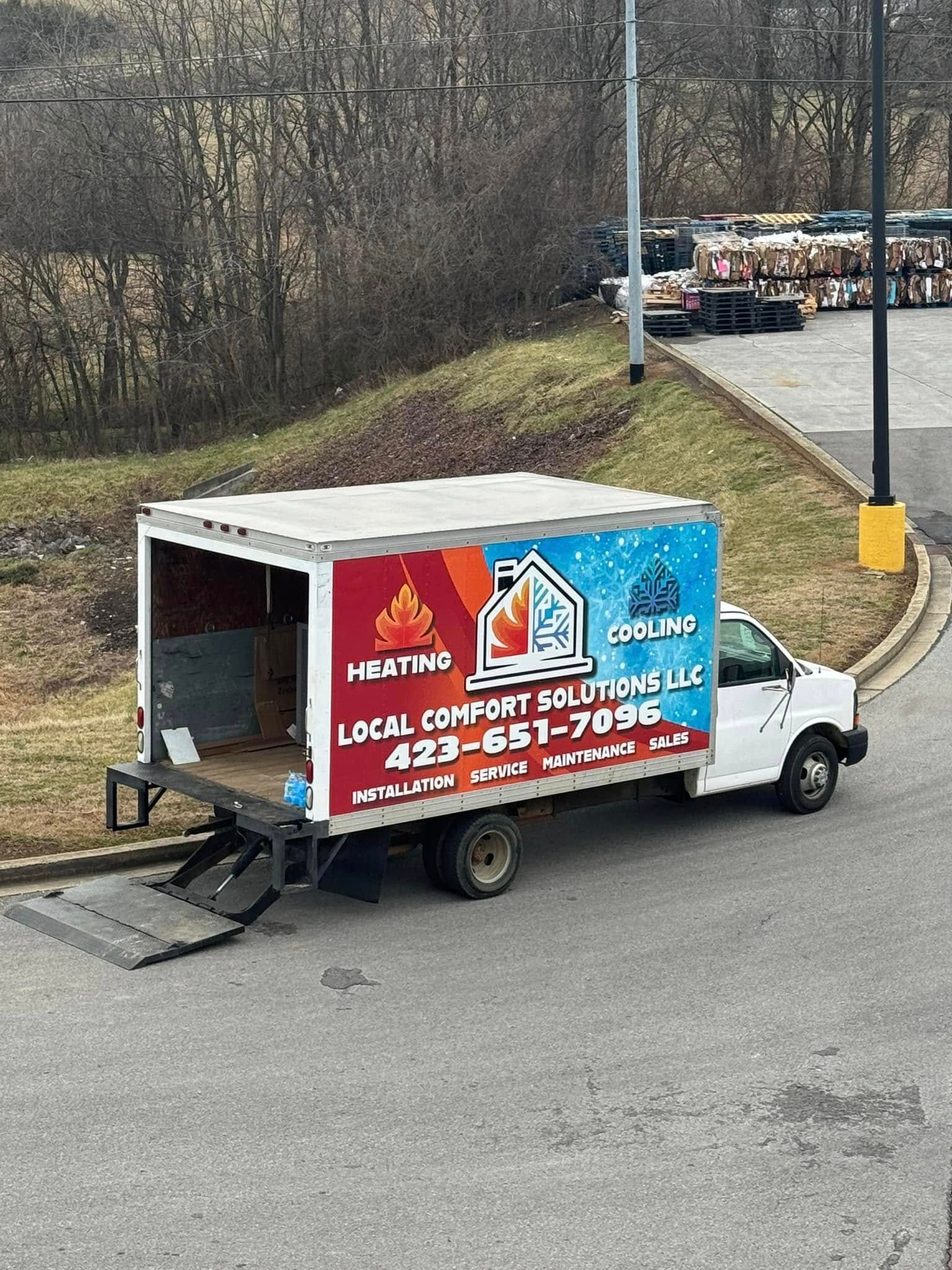 A heating and cooling truck is parked on the side of the road.